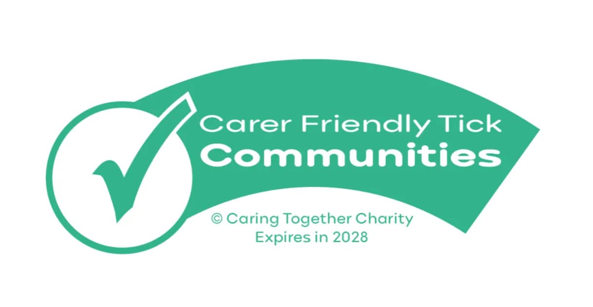 A green and white logo for "Carer Friendly Tick Communities" from the Caring Together Charity, expiring in 2028, featuring a checkmark in a circle.